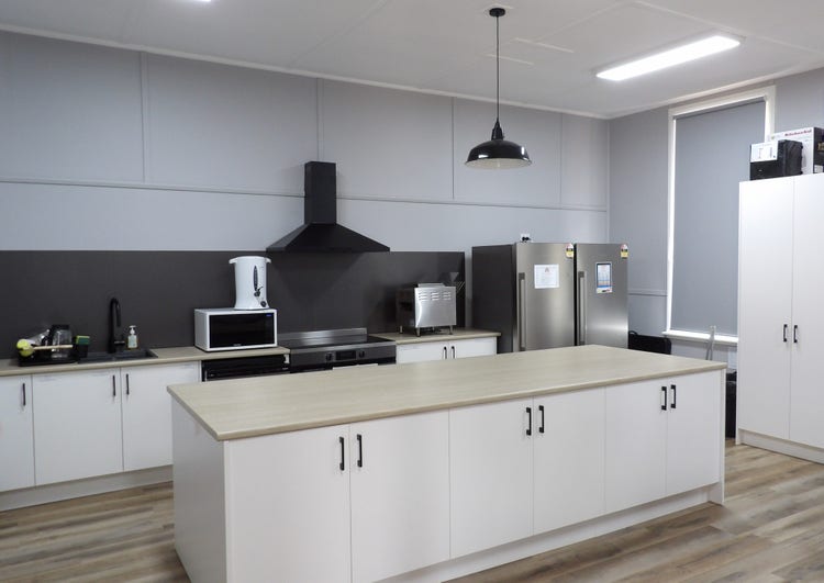 A modern kitchen with island bench and multiple appliances.